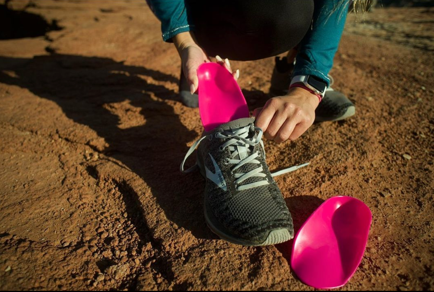Placing a foot medic insole inside of a trail running shoe.